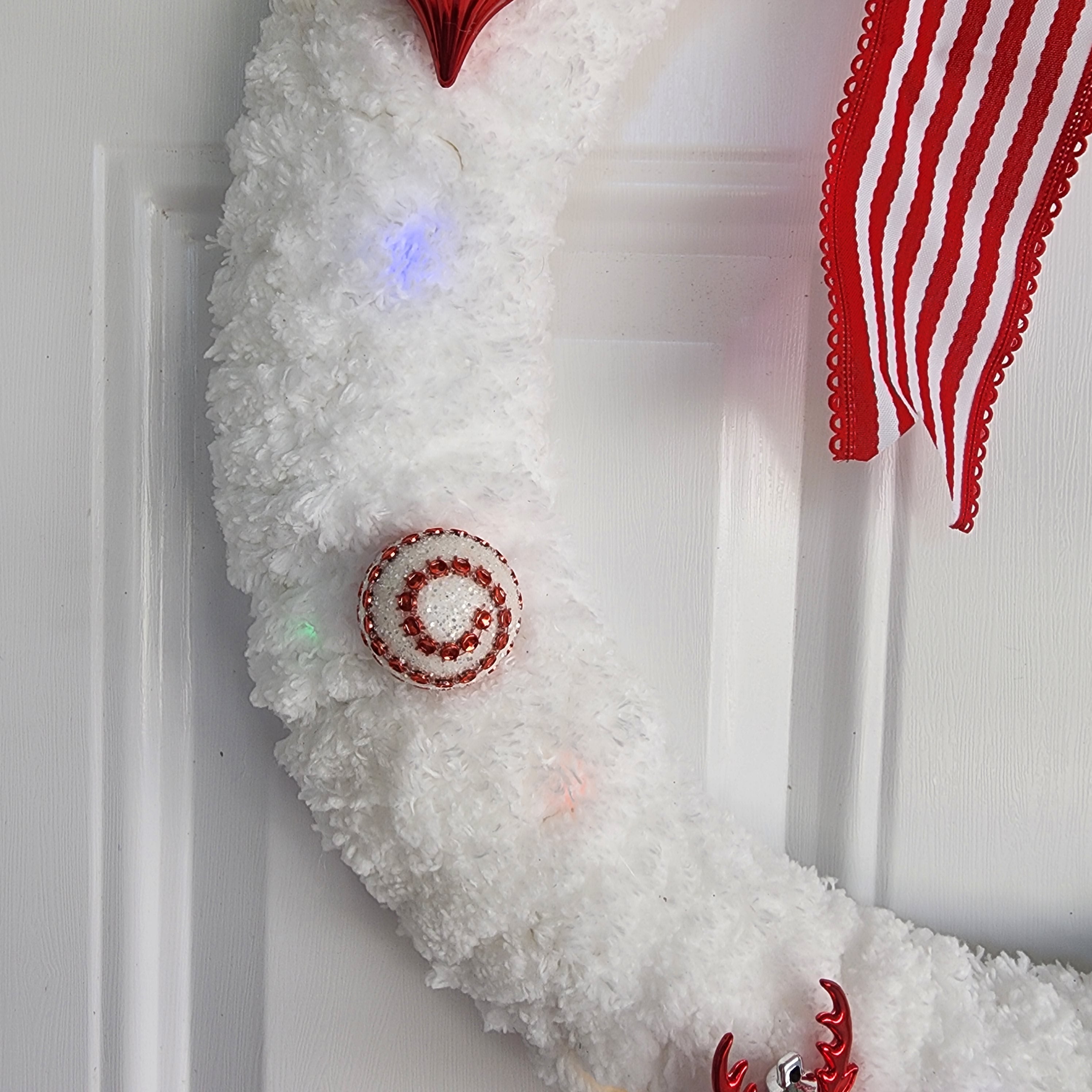 Reindeer ornament and beaded ball detail on white yarn