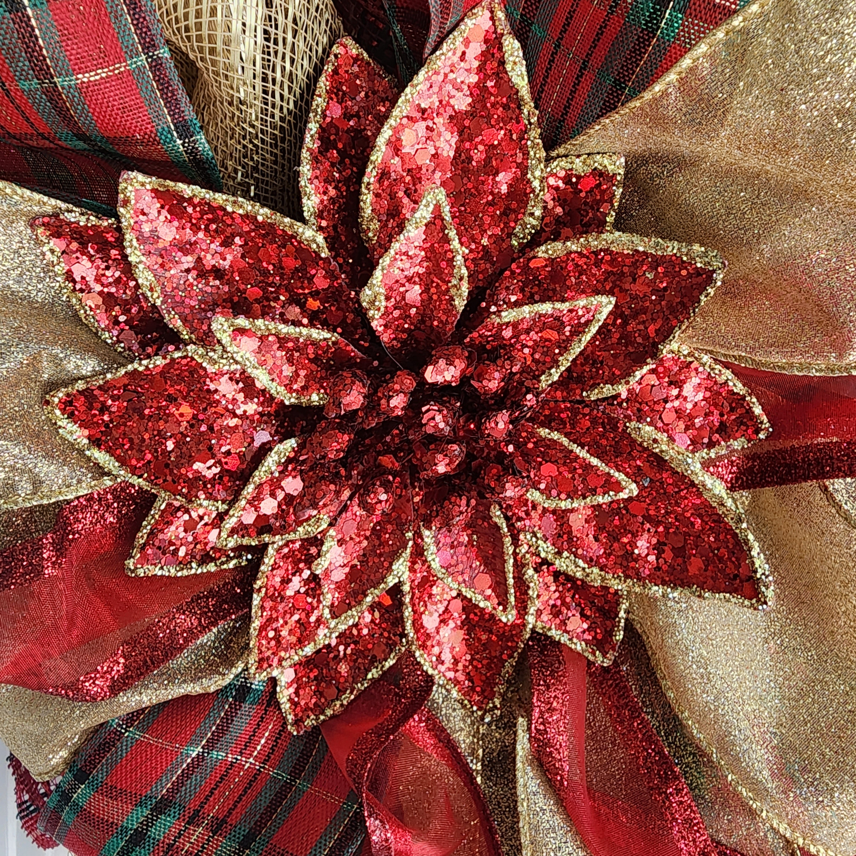 Detail of poinsettia and Merry Christmas sign on wreath