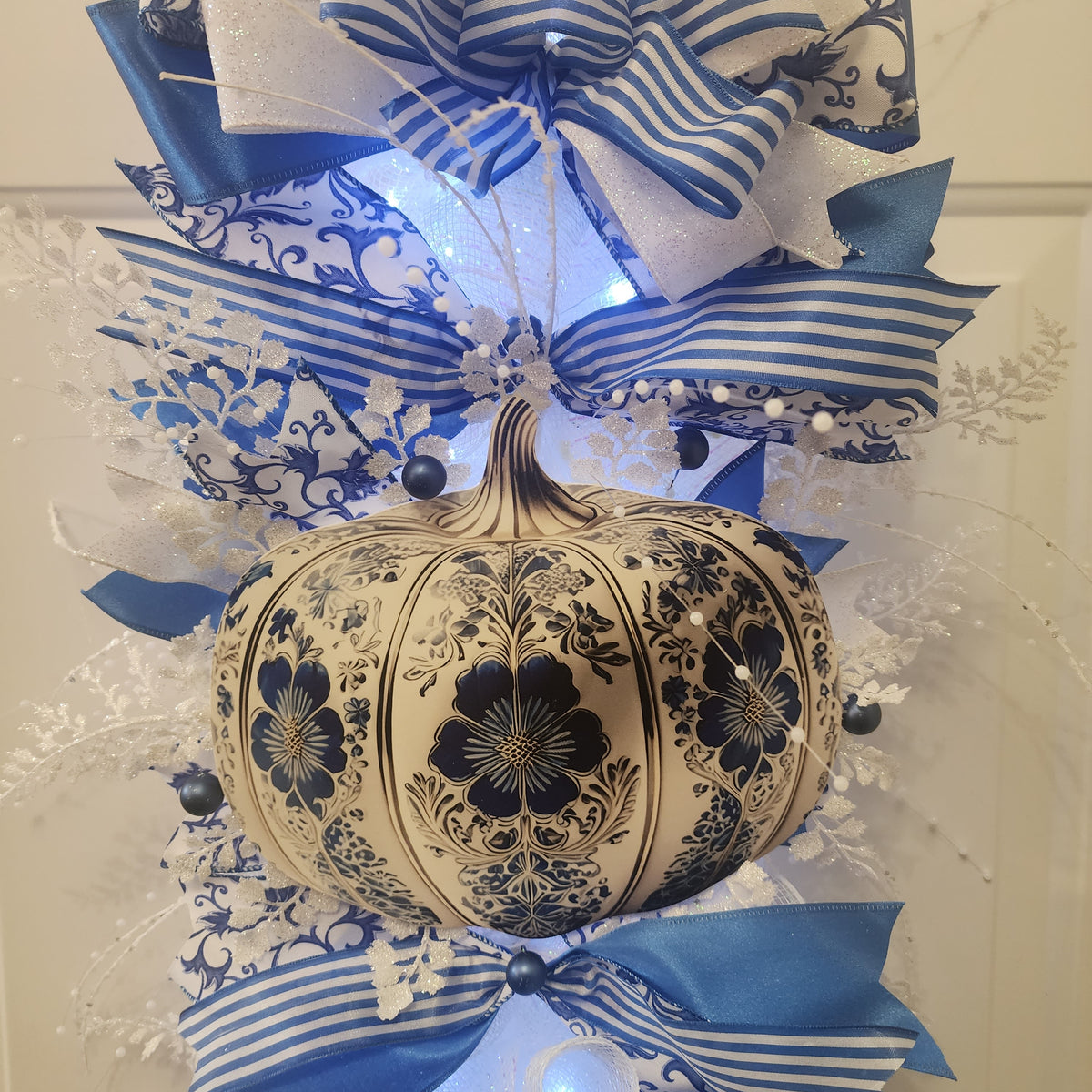 Side view of blue and white chinoiserie door swag on white door