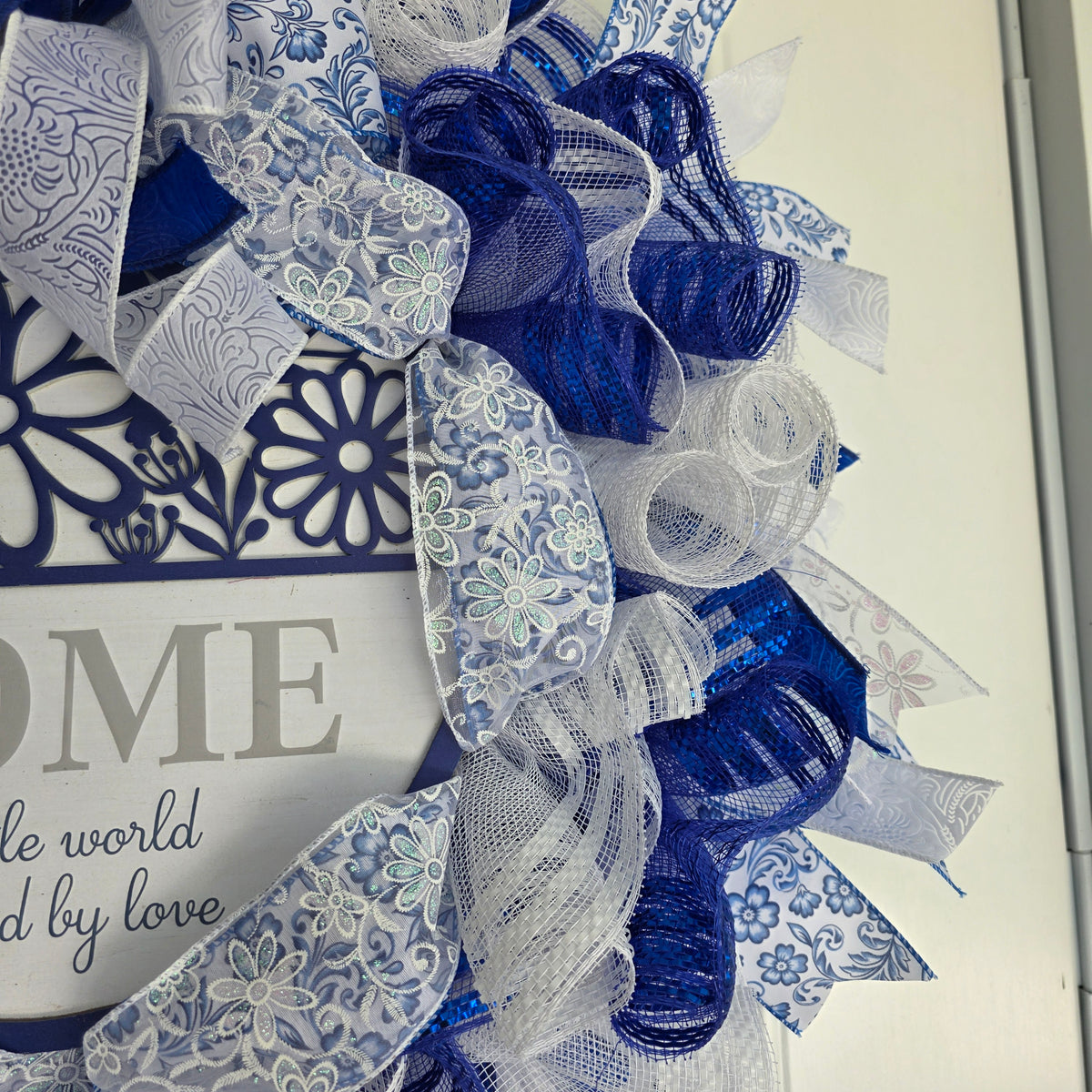 Home A Little World Created By Love Blue White Wreath - sign macro detail