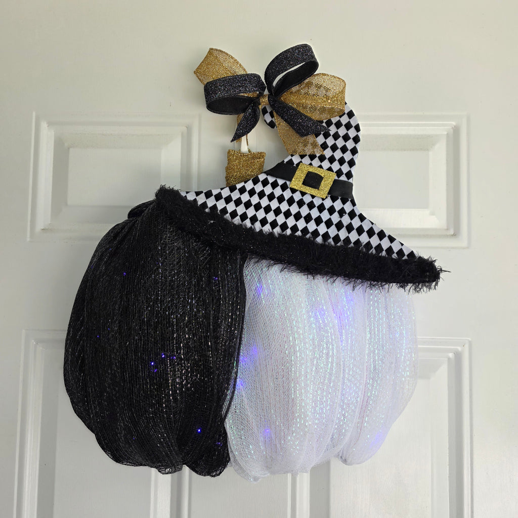 Harlequin Witch Hat LED Pumpkin Wreath - full front view glowing LED lights on white door