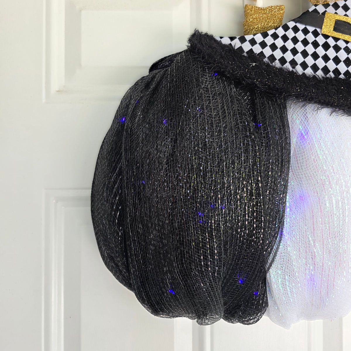 Harlequin Witch Hat LED Pumpkin Wreath - full side angle view on white door