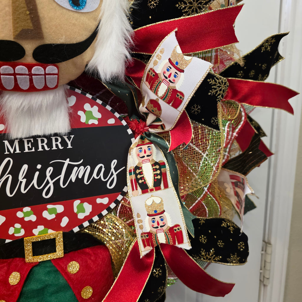 Close up of red and black glitter ribbon bow on nutcracker wreath