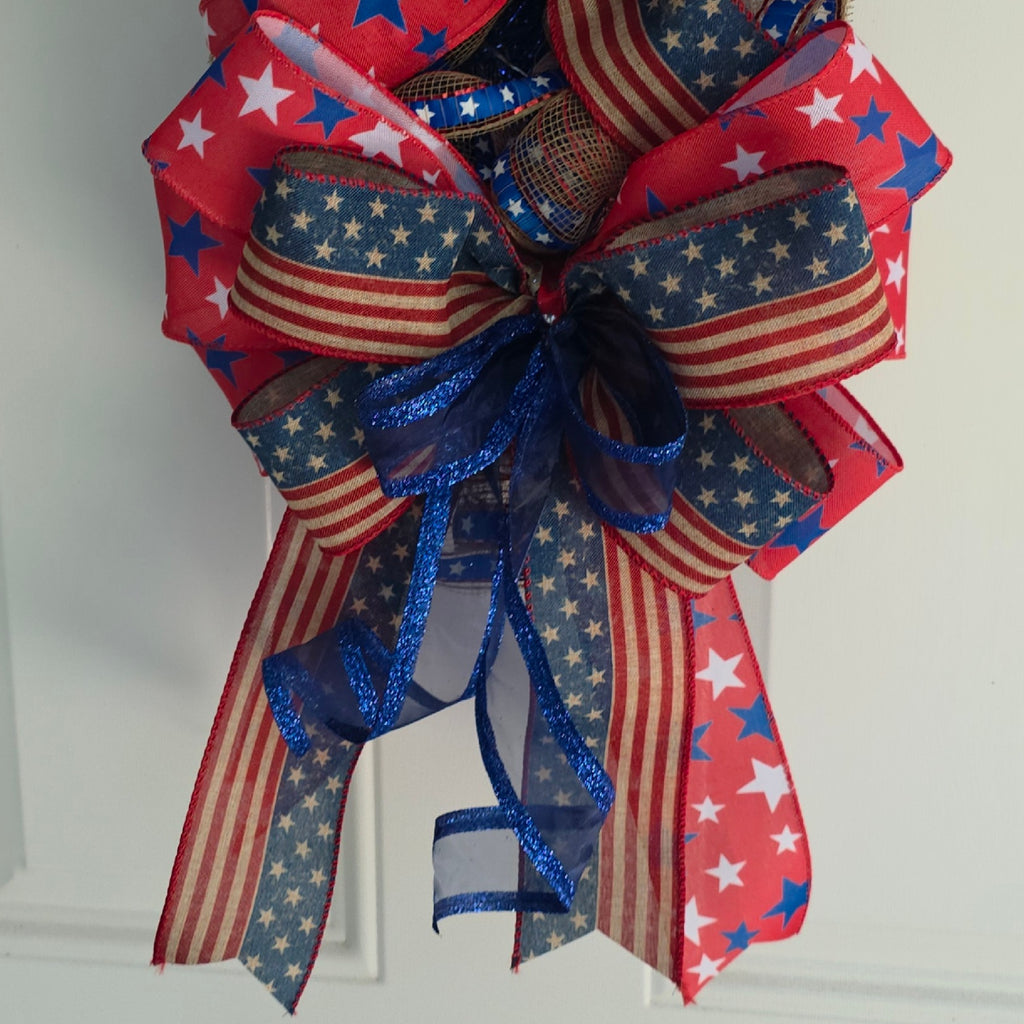 Top bow detail with glittery silver star pick and layered patriotic ribbons