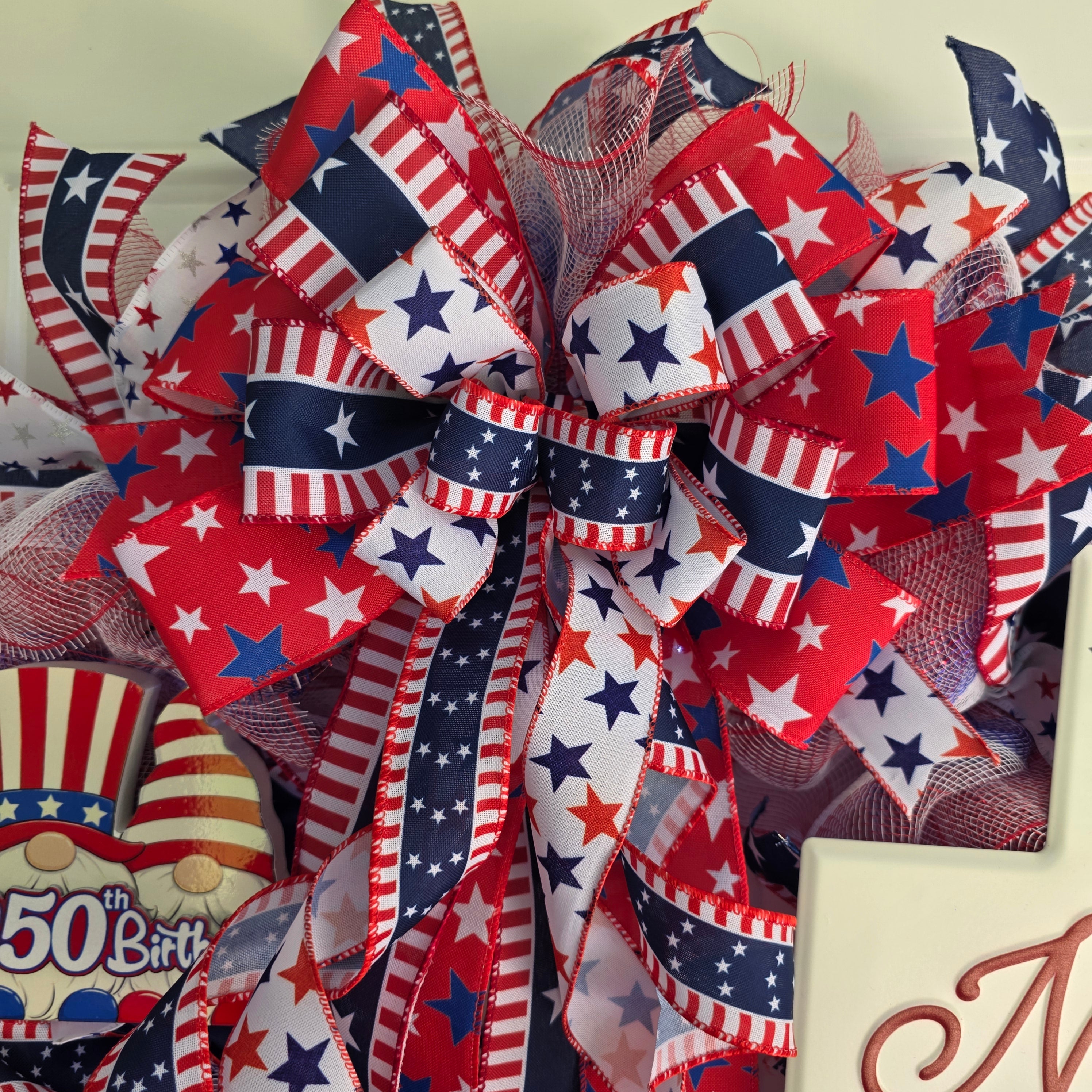 Top bow detail with layered red white blue star and stripe wired ribbons