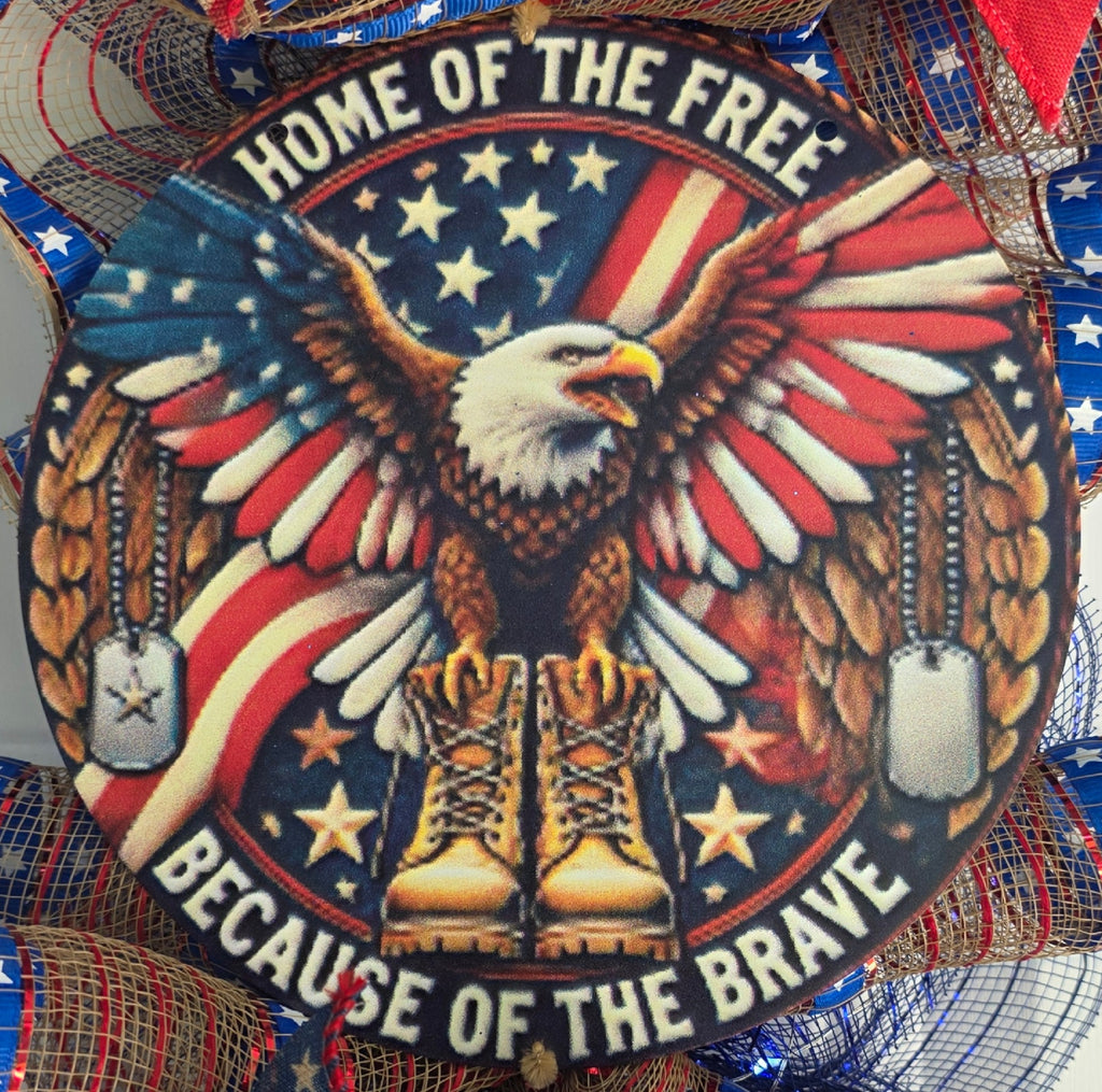 Close-up of Home of the Free Because of the Brave round center sign with eagle combat boots and dog tags
